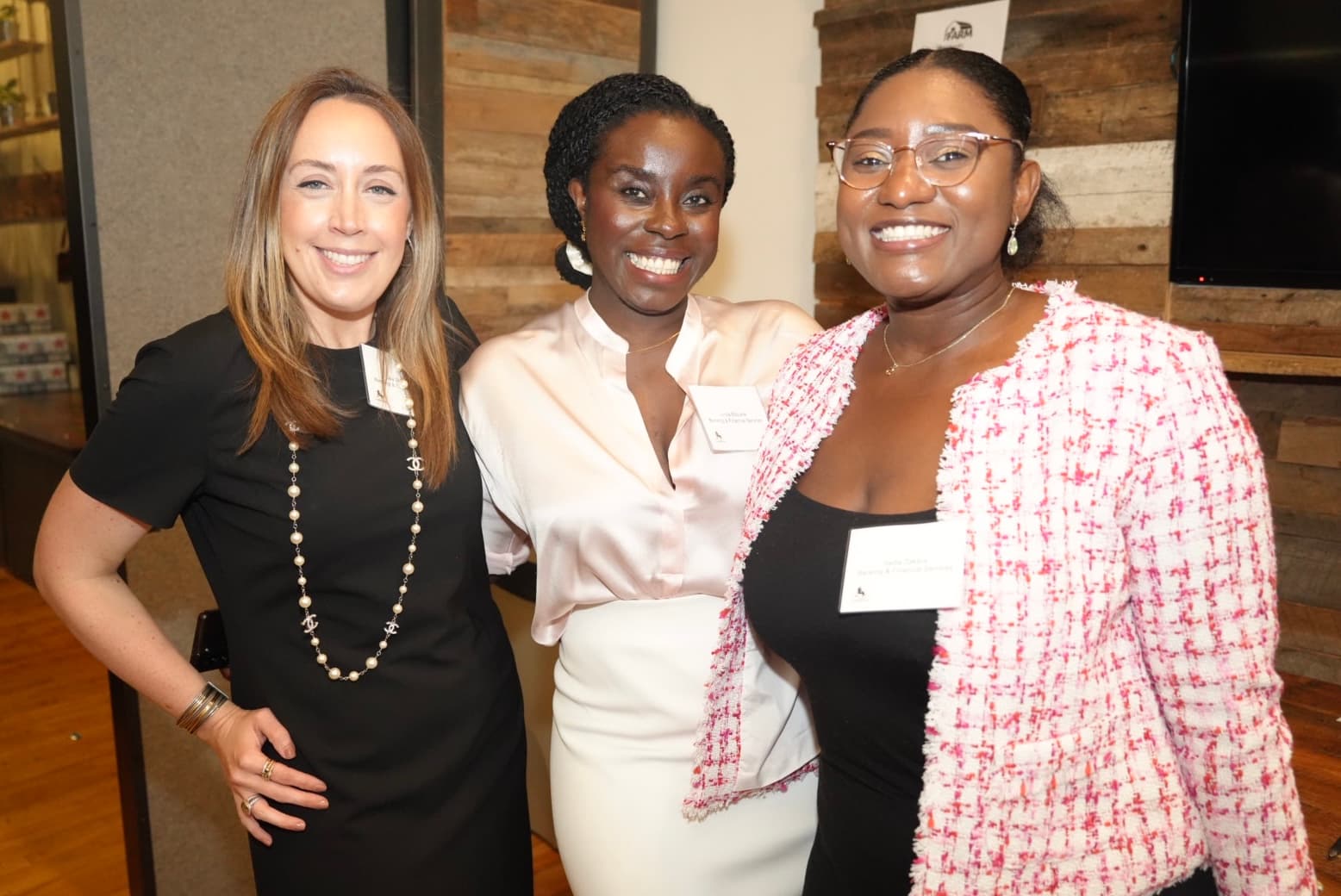 Three women smiling together at a LaddHers gathering